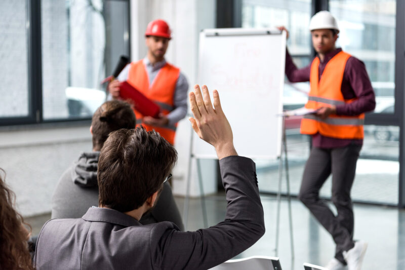 Men in helmets in front of white board