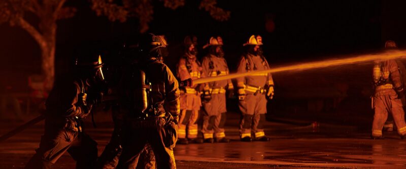 Students using water hose on fire.